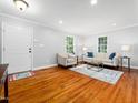 Spacious living room features hardwood floors, neutral décor, and large windows for ample natural light at 1825 Watkins St, Raleigh, NC 27604