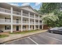 View of the building with exterior white siding and balconies and parking at 1851 Trailwood Heights Ln # 204, Raleigh, NC 27603