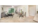 Bright living room with a ceiling fan, dining area, balcony access, and neutral carpet at 1851 Trailwood Heights Ln # 204, Raleigh, NC 27603