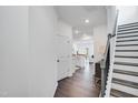 Bright entryway with wood floors leading into a modern kitchen and a staircase at 2019 Nebula Way, Durham, NC 27703