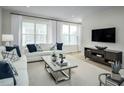 Inviting living room featuring large windows, stylish furnishings, and a modern entertainment center at 2348 Stephens Pass Sta, Apex, NC 27502