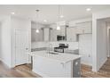 Well-lit kitchen featuring gray cabinets, stainless steel appliances, and a large island with pendant lighting at 324 Longleaf Glen Court, Zebulon, NC 27597