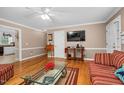 Cozy living room with hardwood floors, striped sofas, and a decorative glass coffee table on an area rug at 402 Hearthstone Dr, Nashville, NC 27856