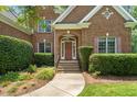 Charming brick home featuring a welcoming front entrance with a manicured lawn and mature landscaping at 4613 Moores Creek Rd, Durham, NC 27705