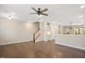 Open concept living room with hardwood floors, a ceiling fan and views of the staircase at 513 Brooks St, Wake Forest, NC 27587