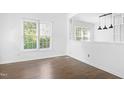 Bright living room showcasing hardwood floors, white walls, with a window view at 613 Penncross Dr, Raleigh, NC 27610