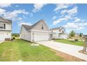 View of a home with vinyl siding, an attached garage and driveway, and green grass at 66 W Emily Gardens Dr, Selma, NC 27576