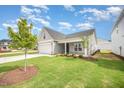 Charming single-Gathering home with a gray exterior, attached garage, and well-manicured lawn at 66 W Emily Gardens Dr, Selma, NC 27576