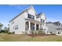 Charming home with a covered porch, stone accents, and lush green lawn, offering a welcoming curb appeal at 713 Ramsours Mill Dr, Holly Springs, NC 27540
