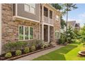 Beautiful exterior view showing the home's stone facade and inviting walkway leading to the front door at 728 Peninsula Forest Pl, Cary, NC 27519