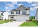 An inviting two-story home with white siding, a gray gable, and a spacious two-car garage at 74 W Emily Gardens Dr, Selma, NC 27576