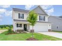 Well-maintained two-story home features stone accents, a well-manicured lawn, and black window shutters at 74 W Emily Gardens Dr, Selma, NC 27576