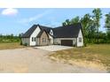 Beautiful exterior view of a two-story home featuring white siding, dark stone accents, and an attached two-car garage at 7620 Sam Hall Rd, Oxford, NC 27565