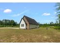 A modern home exterior displays light siding with black stone accent on the gable end in a spacious yard at 7620 Sam Hall Rd, Oxford, NC 27565