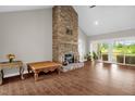 An expansive living room features a striking stone fireplace, wood-look tile floors, and sliding glass doors at 7620 Sam Hall Rd, Oxford, NC 27565