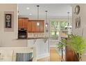 A bar overlooks the kitchen which features stainless steel appliances and granite countertops at 10012 San Remo Pl, Wake Forest, NC 27587
