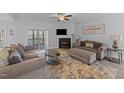 Cozy living room features a fireplace, lake views, and access to a deck, perfect for relaxing and entertaining at 1013 Sagamore Dr, Louisburg, NC 27549