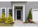 Inviting front entrance with black door, white trim, and manicured landscaping at 120 Misty Grove Trail Trl, Franklinton, NC 27525