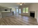 Open-concept living area with a modern fireplace, wood floors, and lots of natural light at 129 Hot Springs Way, Benson, NC 27504