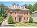 Beautiful brick home showcasing symmetrical design, lush lawn and manicured landscape at 1313 Duplin Rd, Raleigh, NC 27607