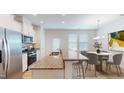 Modern kitchen with granite countertops, stainless steel appliances, and a breakfast bar leading to the dining area at 1365 Scholar Dr, Durham, NC 27703