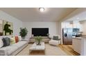 Bright living room featuring a comfortable sofa, stylish accent chair, and modern decor adjacent to the open kitchen at 1365 Scholar Dr, Durham, NC 27703