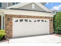 Attached garage with brick facade and windows on garage door at 1831 Devonridge Dr, Fuquay Varina, NC 27526