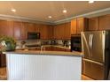 Kitchen featuring wood cabinets, stainless steel appliances, an island and laminate floors at 1831 Devonridge Dr, Fuquay Varina, NC 27526