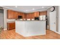 Kitchen featuring wood cabinets, stainless steel appliances, an island and laminate floors at 1831 Devonridge Dr, Fuquay Varina, NC 27526