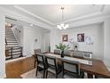 Spacious dining room featuring a large wooden table and chairs, modern lighting, and a view of the staircase at 199 High Woods Rdg, Chapel Hill, NC 27517