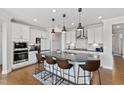 Modern kitchen featuring white cabinets, stainless steel appliances, and a large island with seating at 199 High Woods Rdg, Chapel Hill, NC 27517
