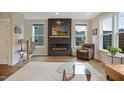 Bright living room features a fireplace with a modern design and natural light through the many windows at 2055 Eva Pearl Dr, Apex, NC 27502