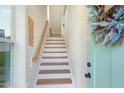 Inviting staircase with white risers, wood treads, and a stylish handrail leading to upper floors at 2055 Eva Pearl Dr, Apex, NC 27502