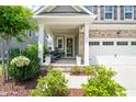 Inviting front porch with elegant columns, landscaping, and tasteful outdoor furniture at 212 Golf Vista Trl, Holly Springs, NC 27540