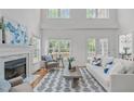 Bright and airy living room with a fireplace, large windows, and hardwood flooring at 2575 Primrose Ln, Creedmoor, NC 27522