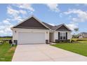 Lovely single-story home with a spacious two-car garage, green lawn, and attractive stone accents at 30 Chloe Ct, Selma, NC 27576