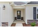 Close-up of the entryway, featuring a stylish door, stone accents, and modern lighting at 30 Chloe Ct, Selma, NC 27576