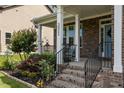 Inviting front porch with brick steps, white columns, and a beautifully landscaped garden at 3032 Curling Creek Drive Dr, Apex, NC 27502