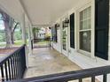 Covered front porch with black railings, white columns, and outdoor lighting fixtures at 306 Penny St, Garner, NC 27529