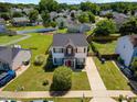 Aerial view of a charming two-story home with well-maintained lawn surrounded by other homes and lush greenery at 3101 Riverbrooke Dr, Raleigh, NC 27610