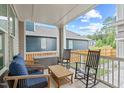 Relaxing covered porch featuring comfortable seating and a view of the backyard at 3310 Mission Olive Pl, New Hill, NC 27562
