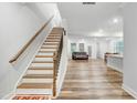 Bright entryway featuring hardwood floors, a staircase with wooden handrail, and views to the living area at 333 Natsam Woods Way, Wake Forest, NC 27587