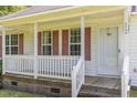 Close-up of a charming front porch with classic white railing and red shutters at 3336 Piney Grove Wilbon Rd, Fuquay Varina, NC 27526