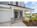 Welcoming front porch with stone pillars and a stylish blue front door with glass inserts at 44 Chloe Ct, Selma, NC 27576