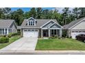 Beautiful single-story home features a manicured lawn, brick accents, a two-car garage, and an inviting front porch at 440 Bramble Ln, Clayton, NC 27527