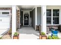 Inviting front porch features stone accents, comfortable seating, and a welcoming entrance to this charming home at 440 Bramble Ln, Clayton, NC 27527