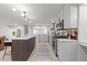 Modern kitchen with a large island, white cabinetry, stainless appliances, and decorative tile backsplash at 4812 Latimer Rd, Raleigh, NC 27609