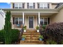 Inviting front porch with stone steps, railing, and a decorative front door at 52 Summit Overlook Dr, Clayton, NC 27527