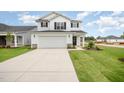 Charming two-story home featuring a two-car garage, well-maintained lawn, and classic black-and-white color scheme at 58 W Emily Gardens Dr, Selma, NC 27576