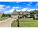 Landscaped front yard with a view of a craftsman-style home and a lengthy driveway at 71 Smithsanders Ct, Smithfield, NC 27577